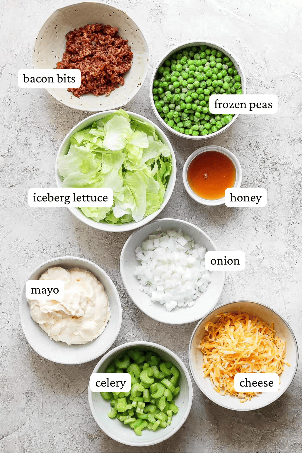 Ingredients for seven layer salad in separate bowls.