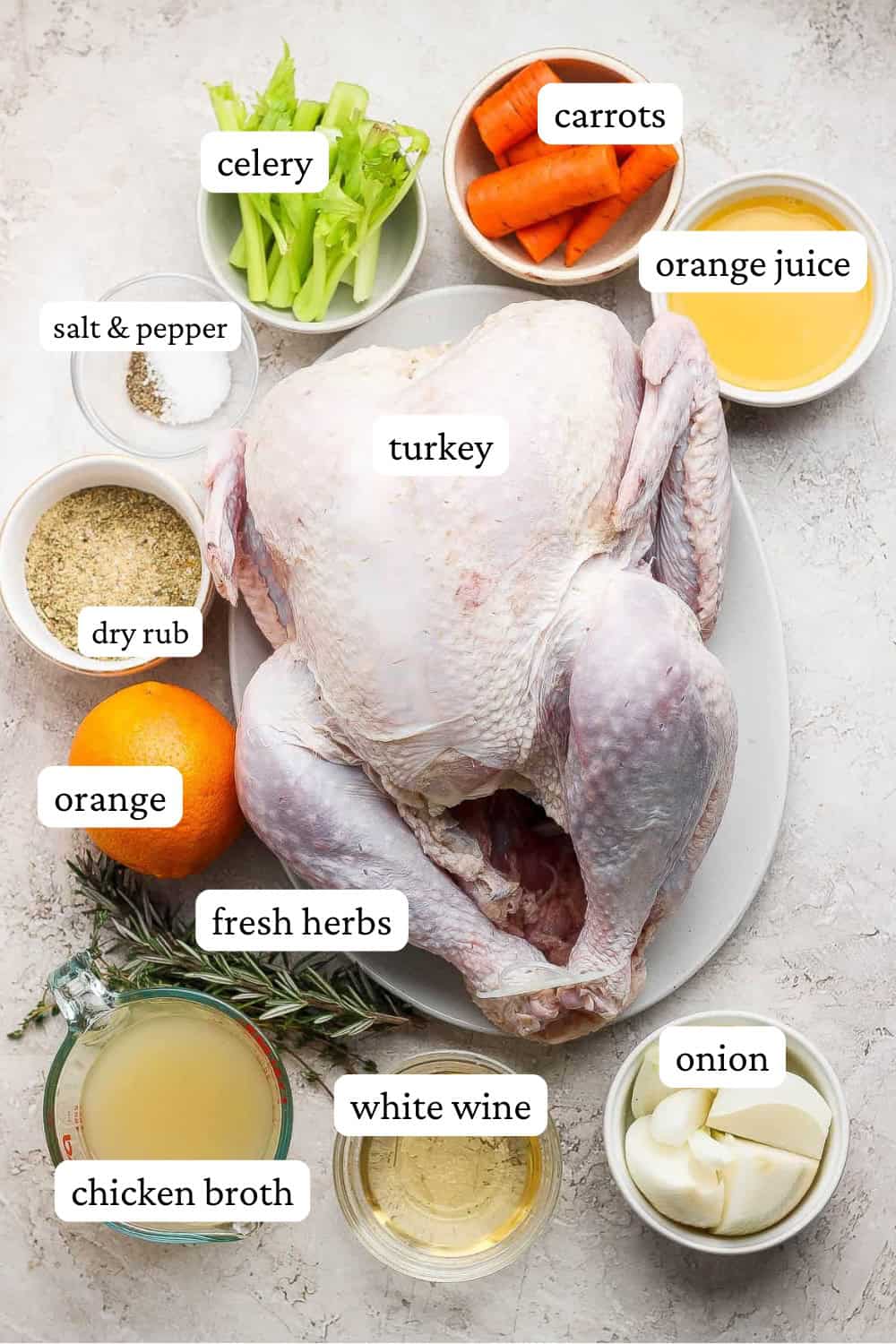 Ingredients for an orange turkey in separate bowls surrounding a whole thawed turkey.