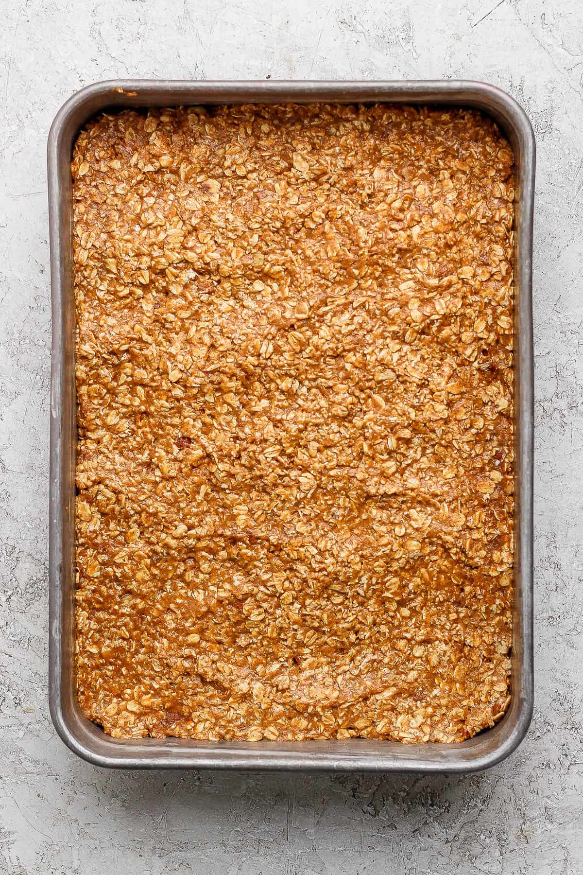 A metal pan of pumpkin baked oatmeal before baking.