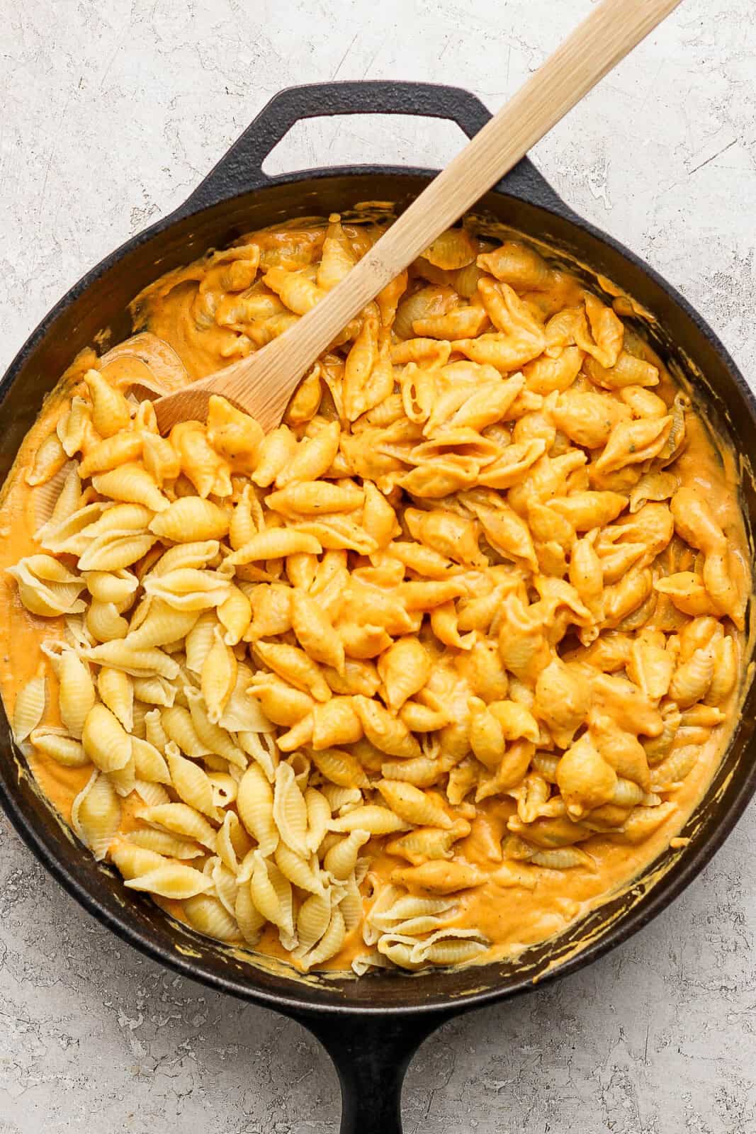 Cooked shell noodles added to the cheese mixture in the skillet.