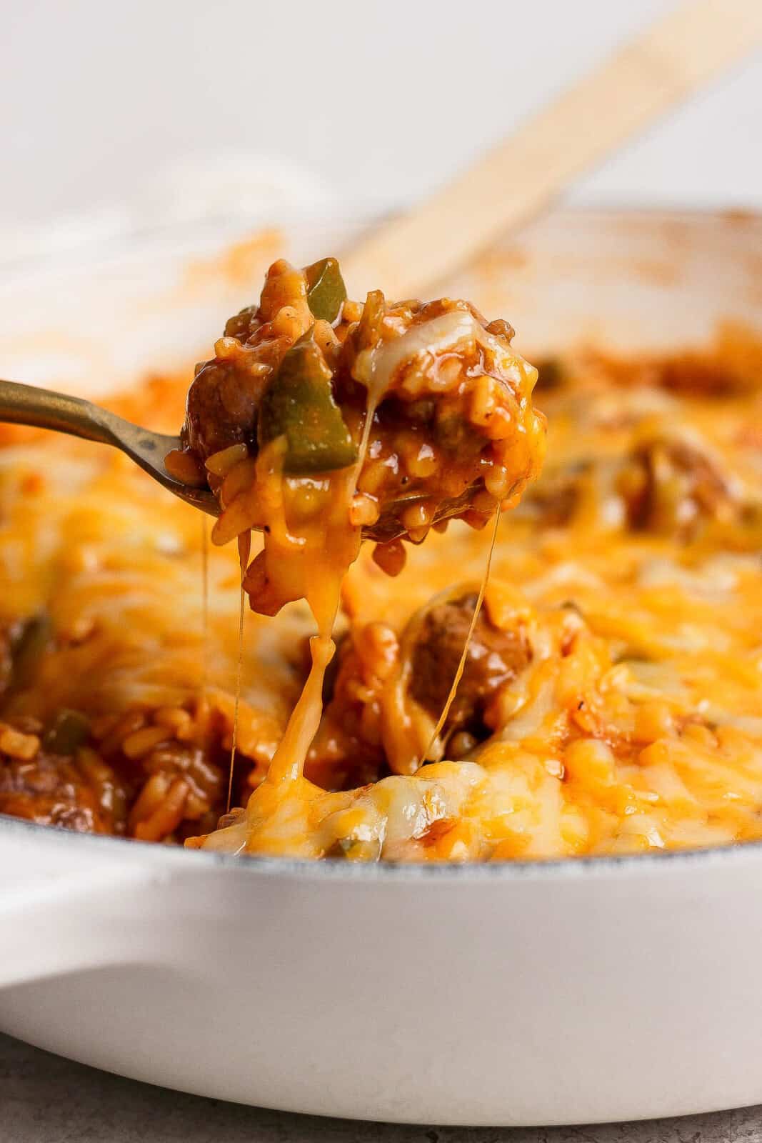 A spoon scooping some sloppy joe orzo out of the pan.
