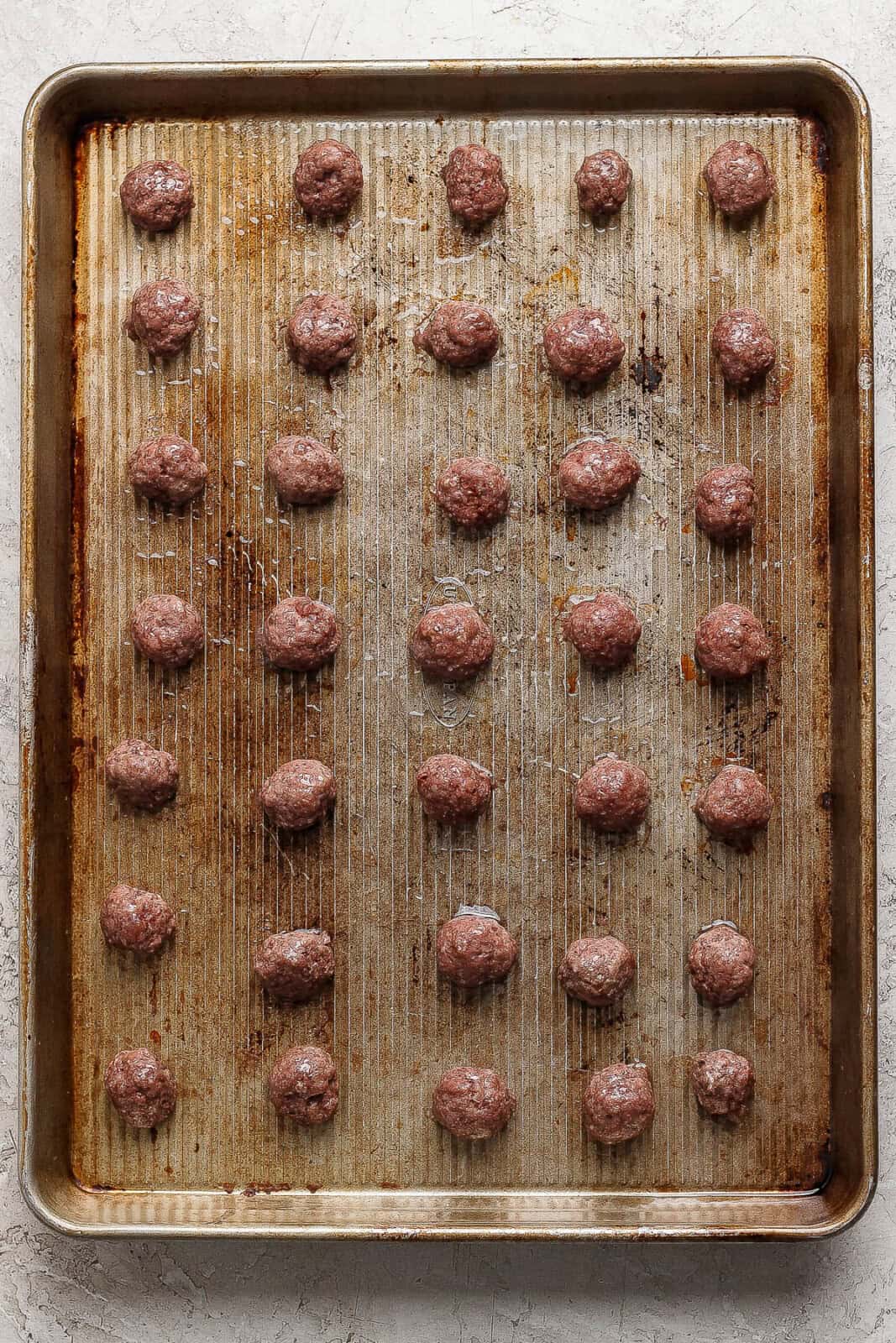 Baked mini meatballs on a sheet pan.