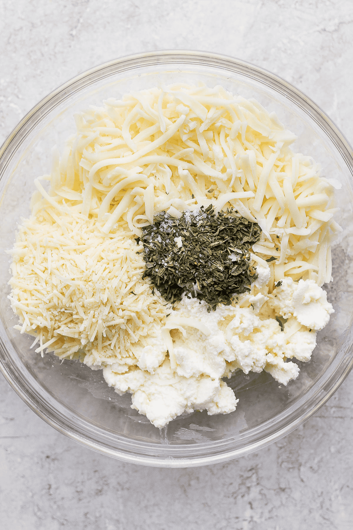 Ingredients for the ricotta mixture in lasagna soup separated in a glass bowl.