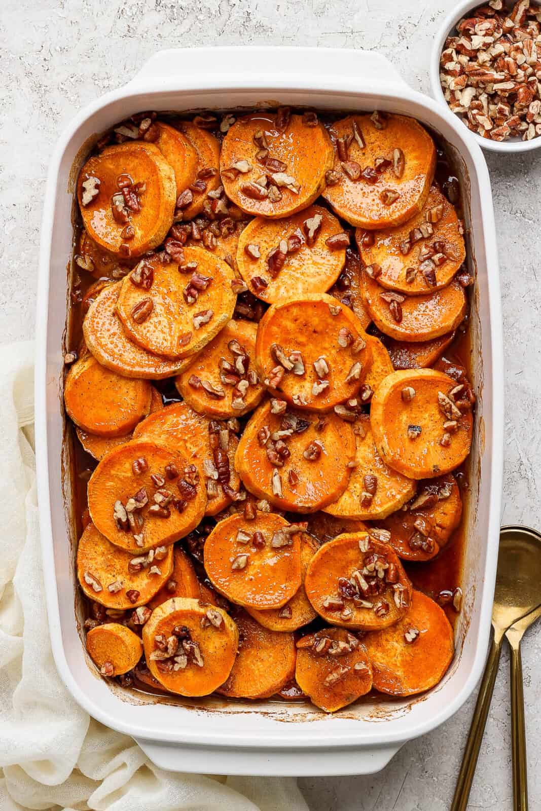 Cooked candied yams topped with pecans.