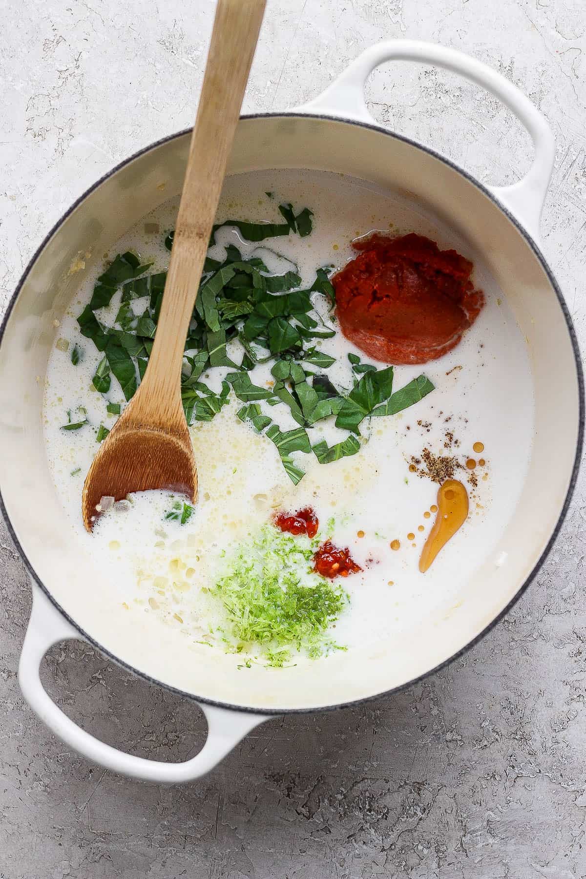 All of the ingredients for pot sticker soup in a dutch oven, except for broth, potstickers, mushrooms, and bok choy.