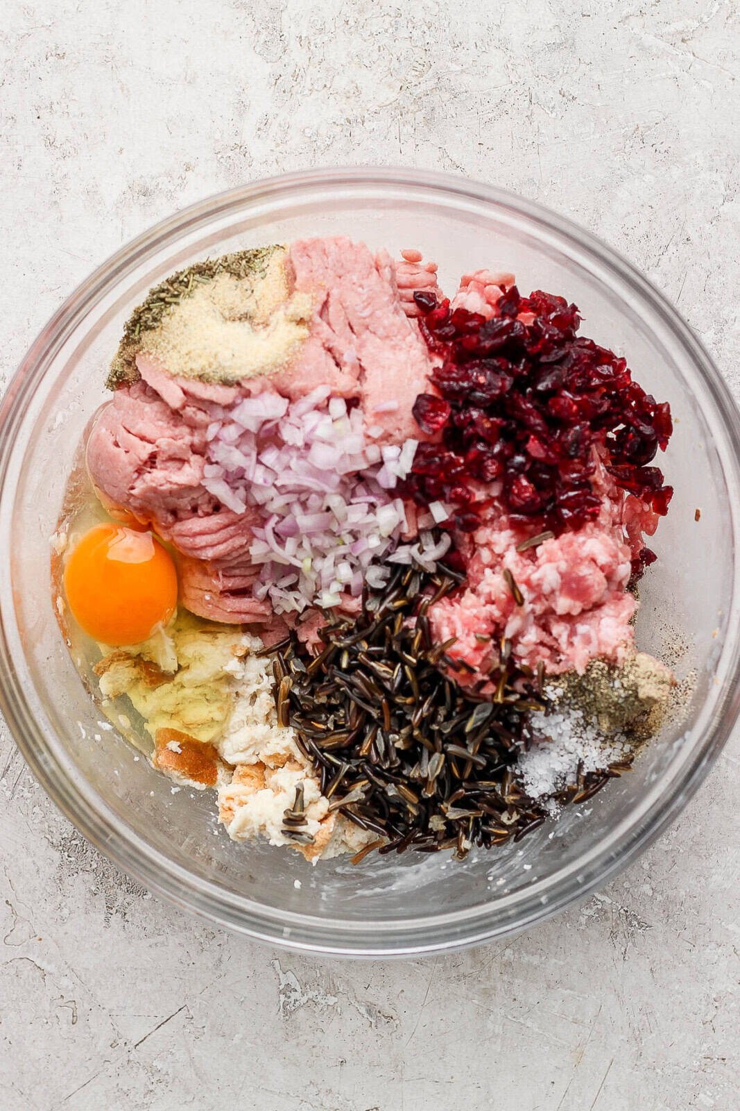 Thanksgiving meatball ingredients all added to a bowl unmixed.