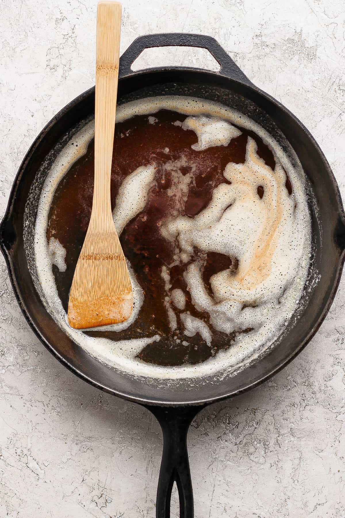 Browned butter in a cast iron skillet with a wooden spoon.