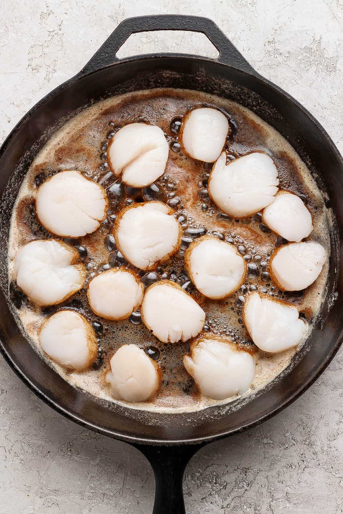 Scallops added to the browned butter in a cast iron skillet.
