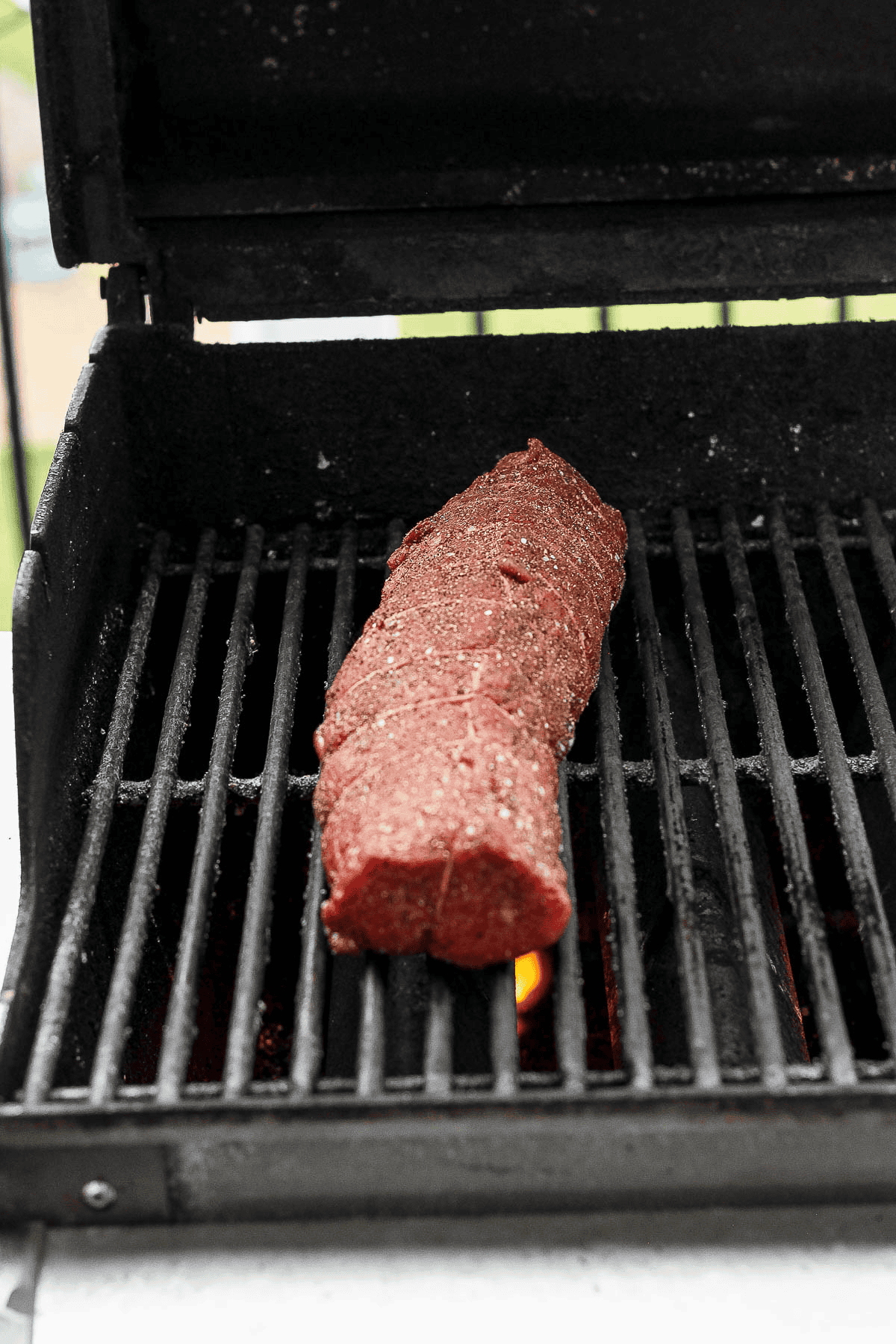 A seasoned beef tenderloin on the grill.