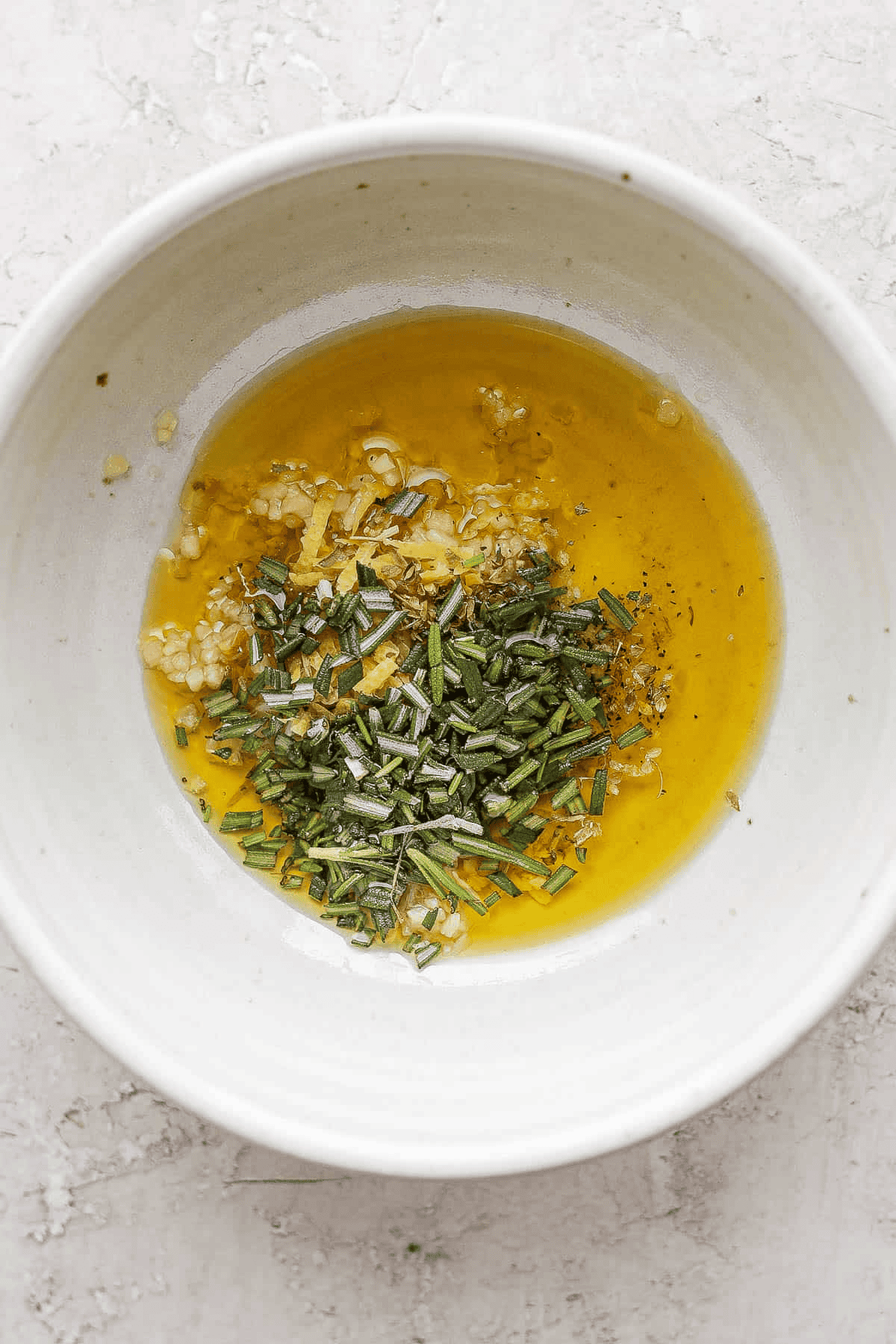 Lamb chop marinade ingredients in a white bowl before being mixed.