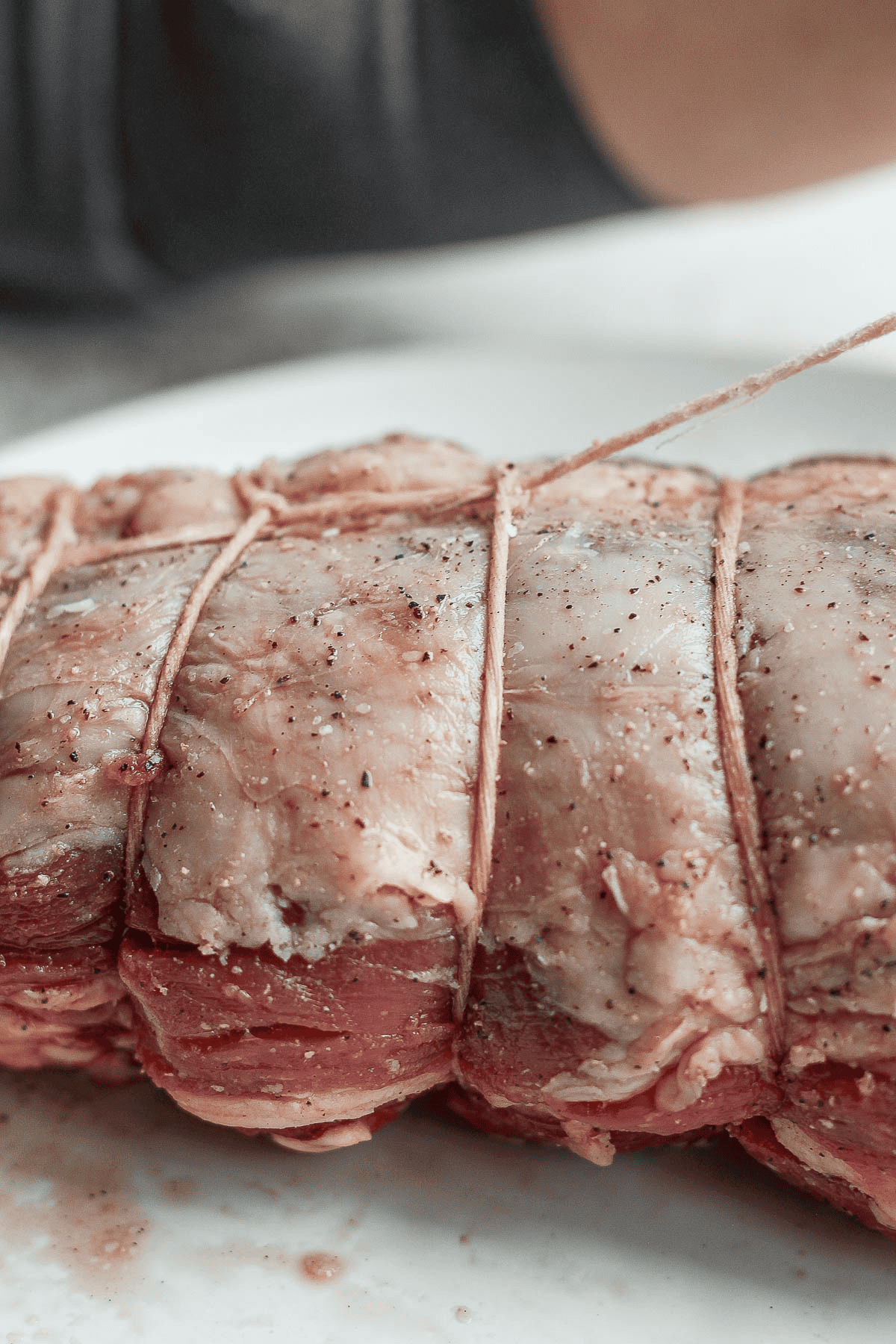 Three knots of kitchen twine around a beef tenderloin.