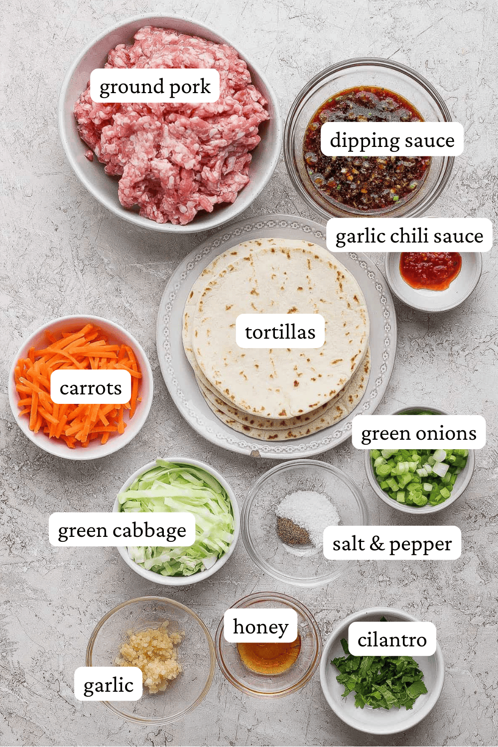 Smash dumpling taco ingredients in separate bowls with labels.