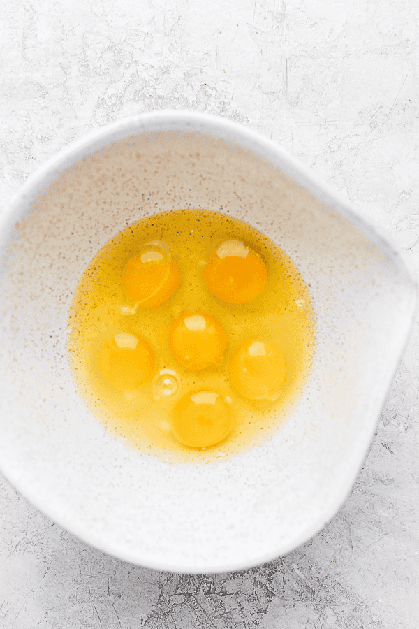 Several eggs cracked in a large mixing bowl.