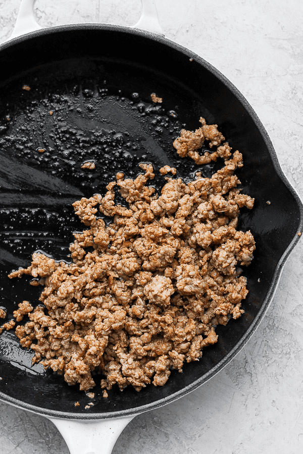 Browned sausage in a small cast iron skillet.