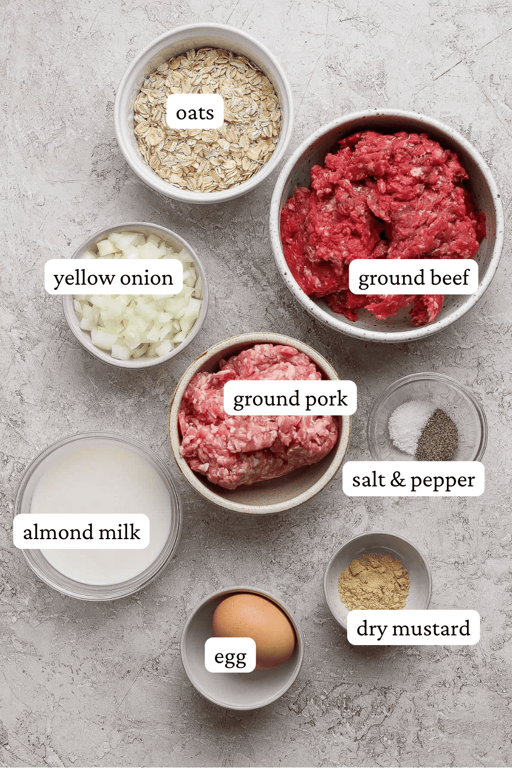 Ingredients for healthy meatloaf in separate bowls with labels.