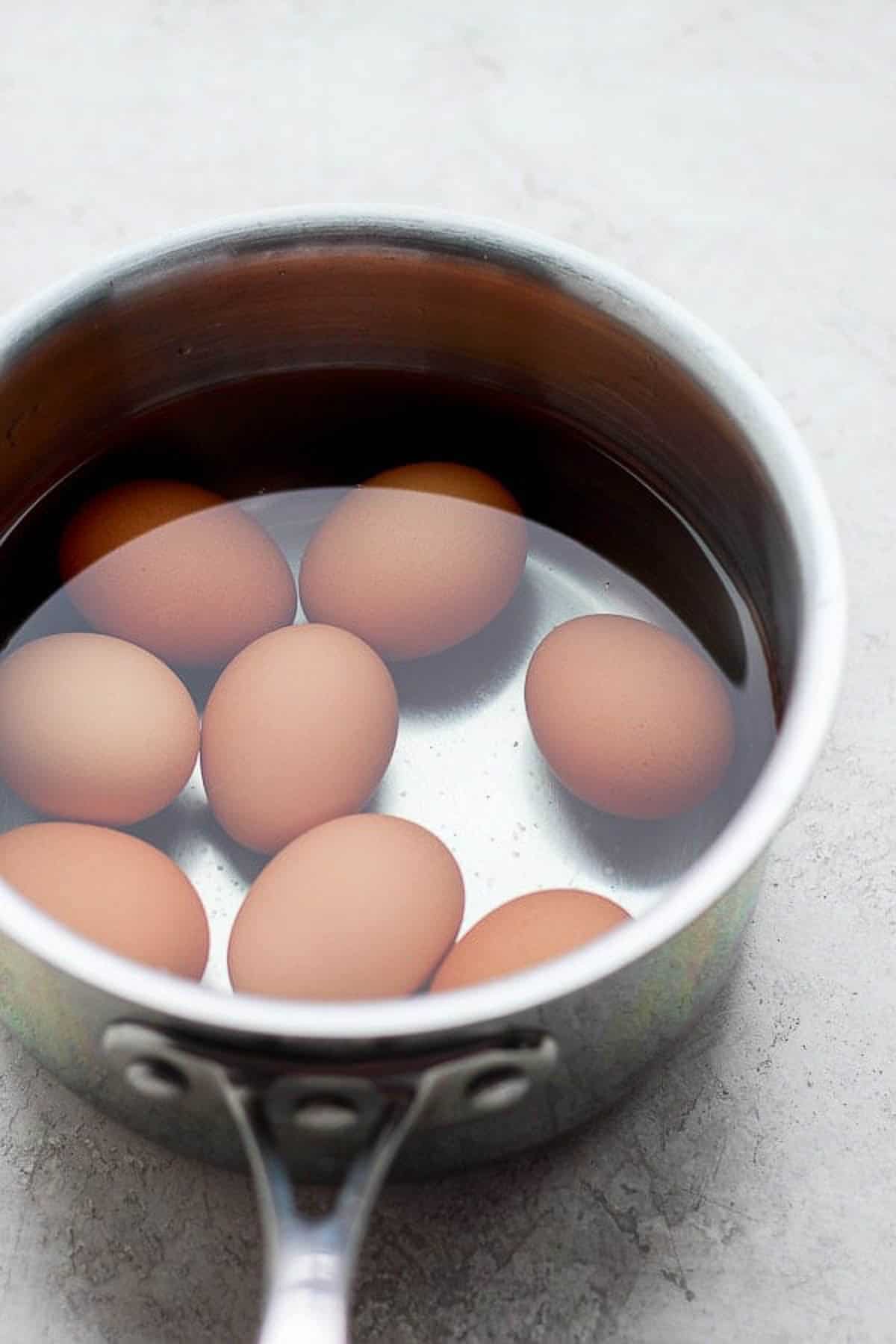 Several eggs cooking in a pot of water.