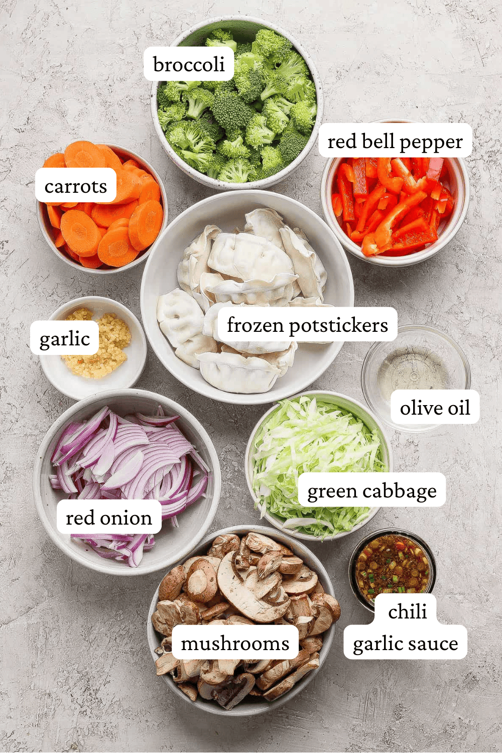 Ingredients for potsticker stir fry in separate bowls with labels.