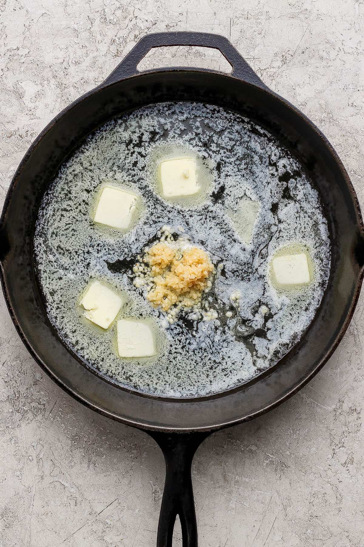 Melted butter and garlic in a cast iron skillet.
