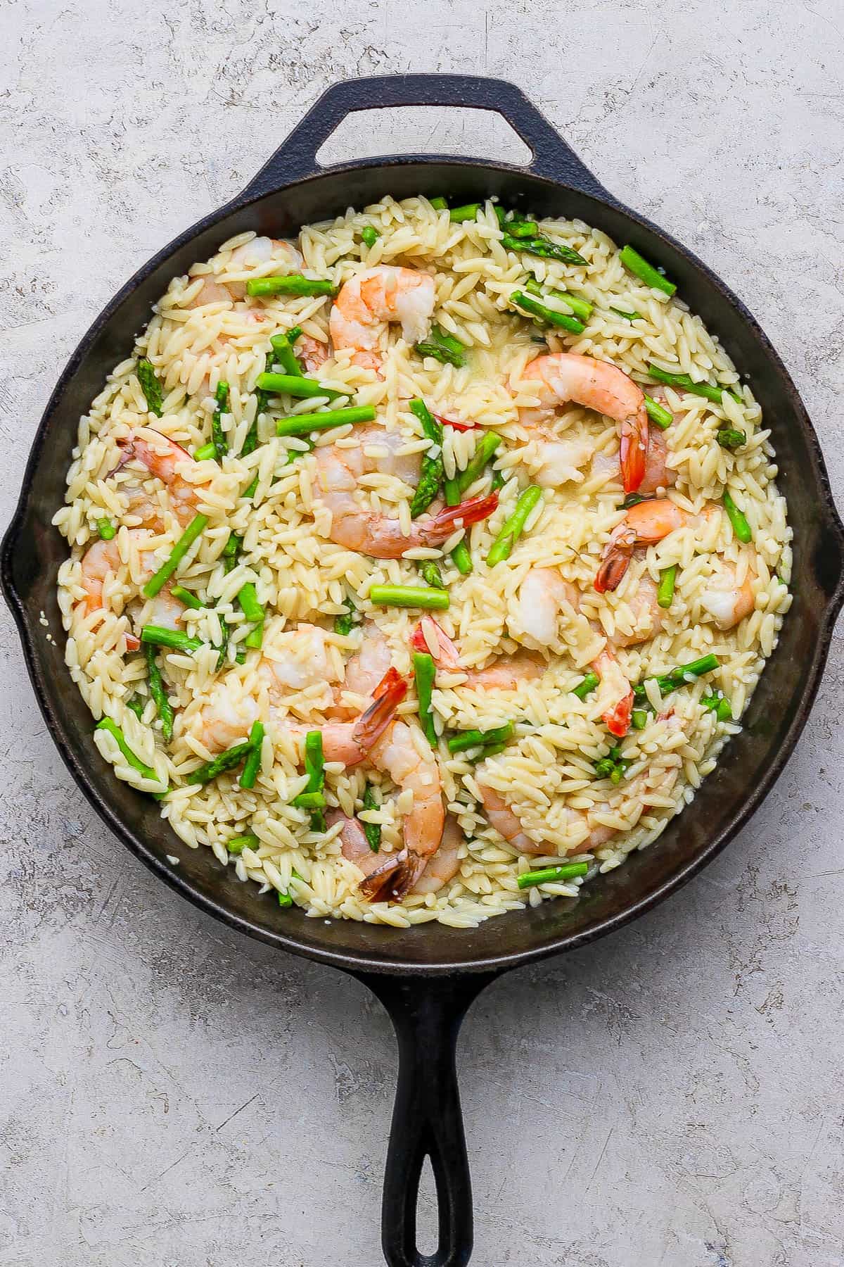 Shrimp scampi with orzo fully cooked in a cast iron skillet.