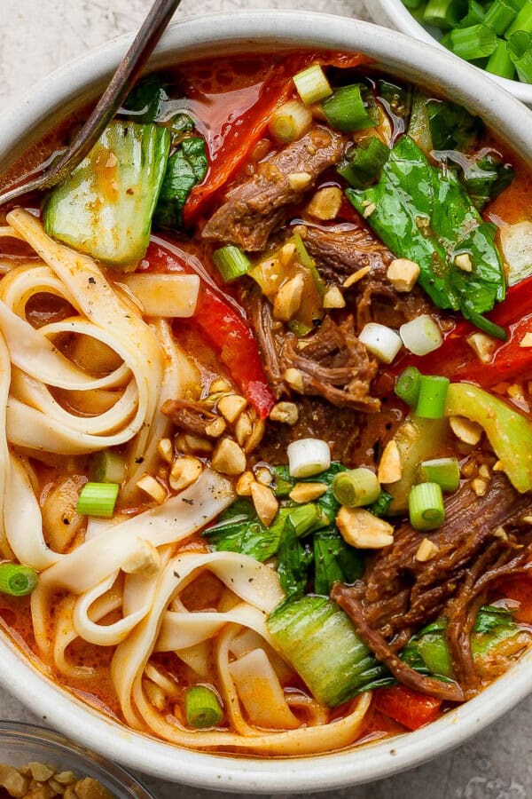 Bowl of beef short rib soup with a spoon sticking out the side.