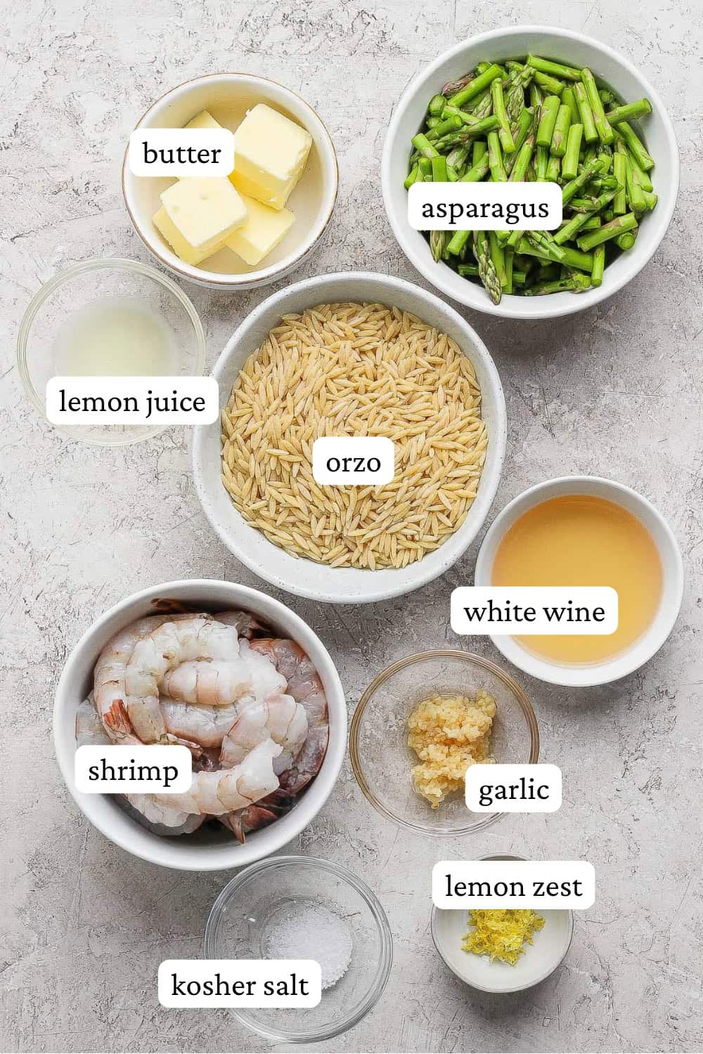 Ingredients for shrimp scampi with orzo in separate bowls with labels.