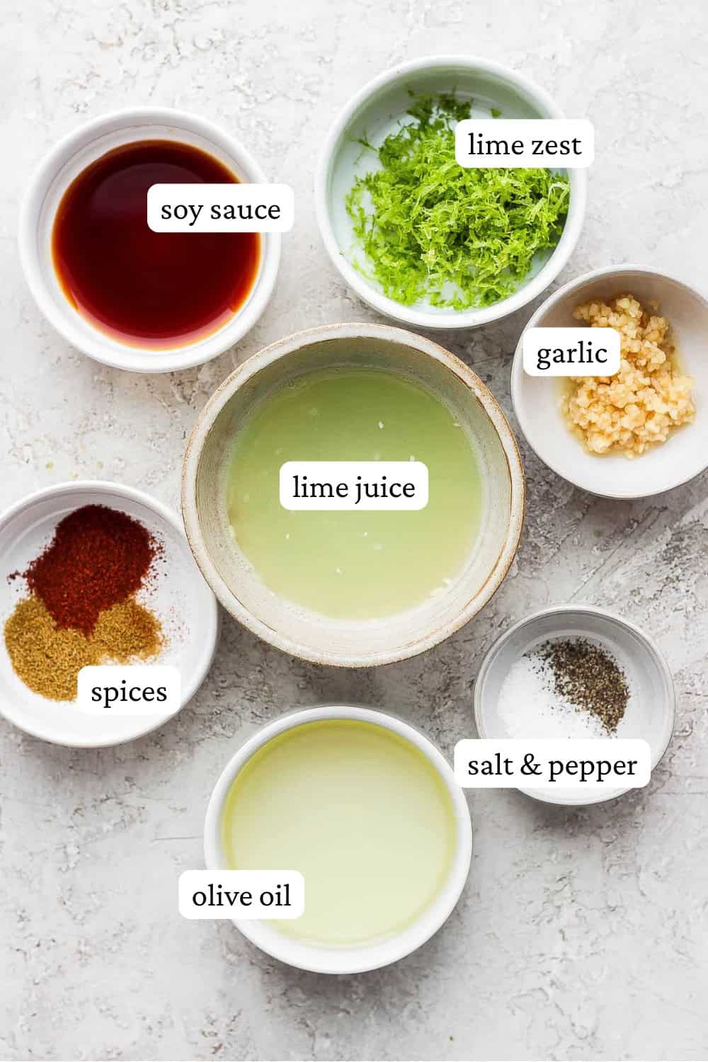 Ingredients for a steak fajita marinade in separate bowls with labels.