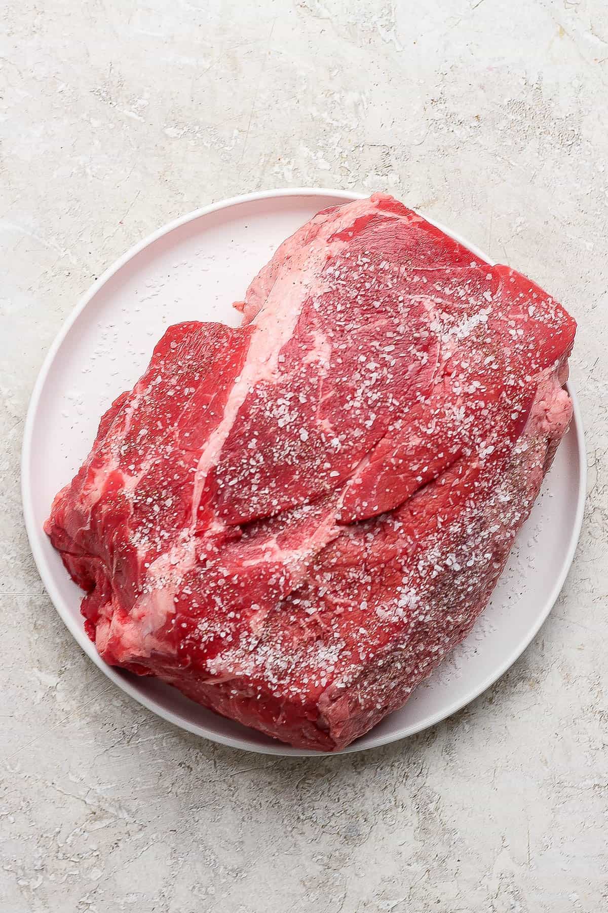 Seasoned beef chuck roast on a plate to make dutch oven mississippi pot roast.