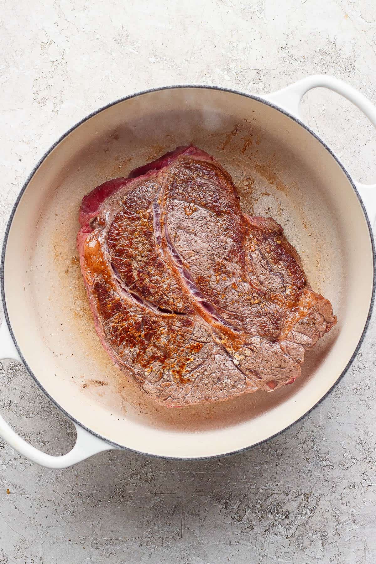 Seared beef chuck roast in a dutch oven to make dutch oven mississippi pot roast.