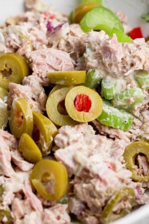 A fully mixed healthy tuna salad with olives in a bowl.