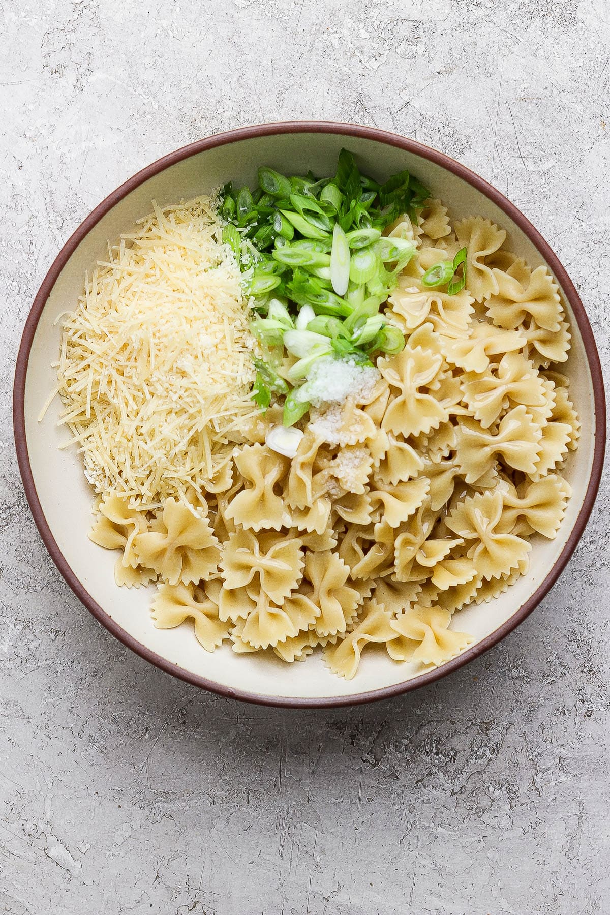 Lemon pasta salad in a serving bowl before being mixed together.