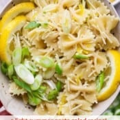 A hand holding a bowl of lemon pasta salad with the text, "lemon pasta salad".
