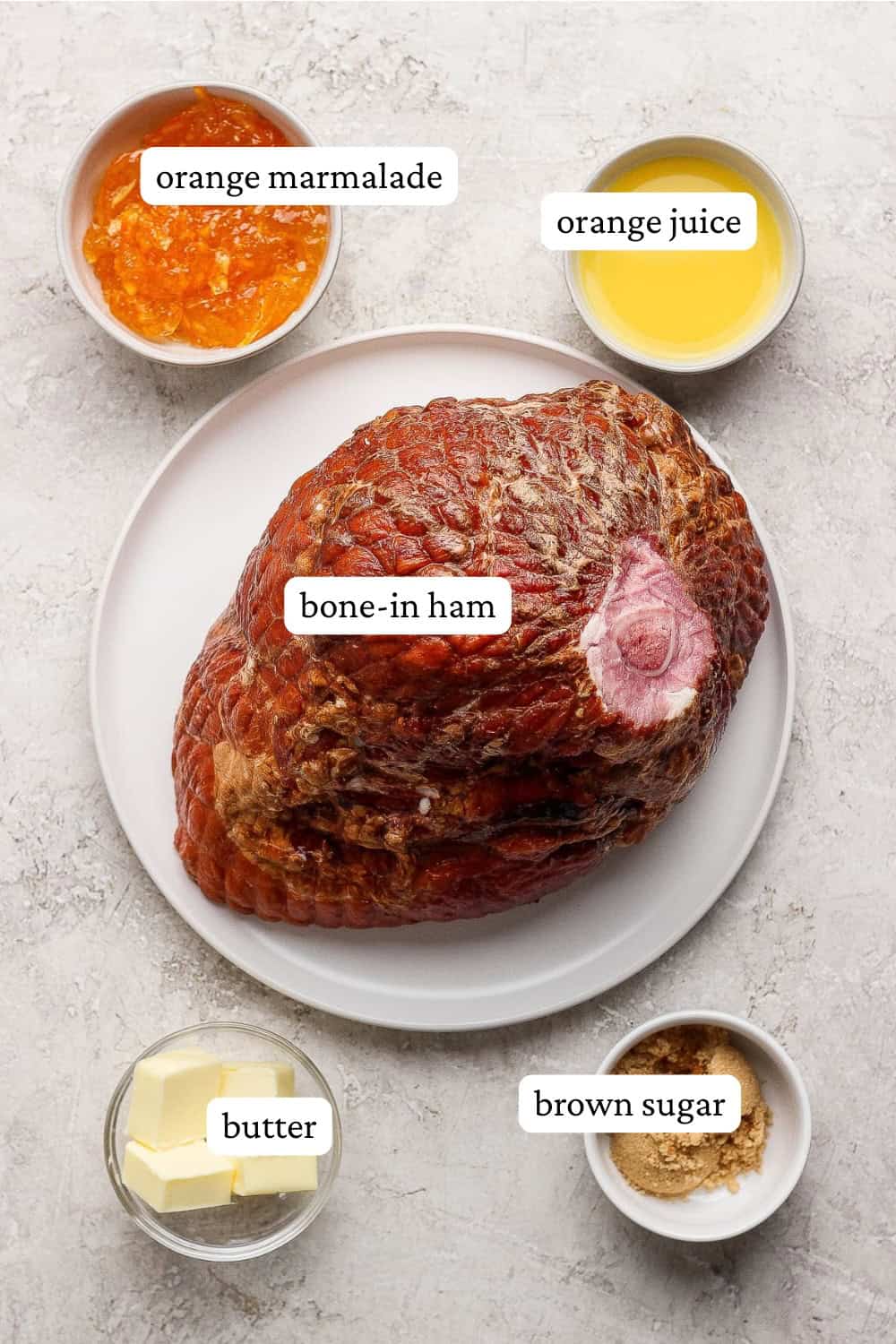 Ingredients for an orange glazed ham in separate bowls with labels.