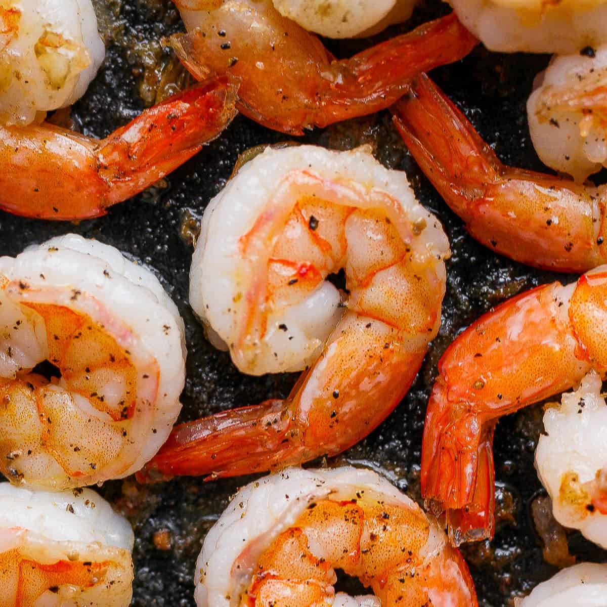 Fully cooked pan fried shrimp in a cast iron skillet.