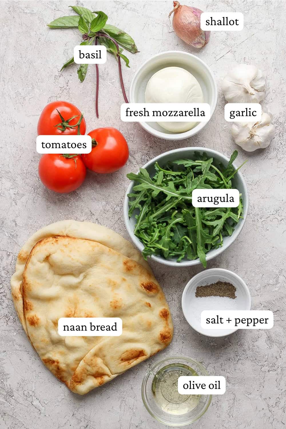 Ingredients for roasted garlic pizza on the counter or in bowls with labels.