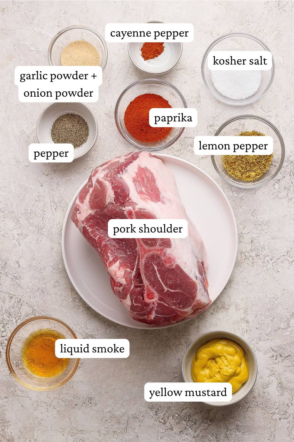 Ingredients for slow cooker pulled pork in small bowls around the pork shoulder on a plate with labels.