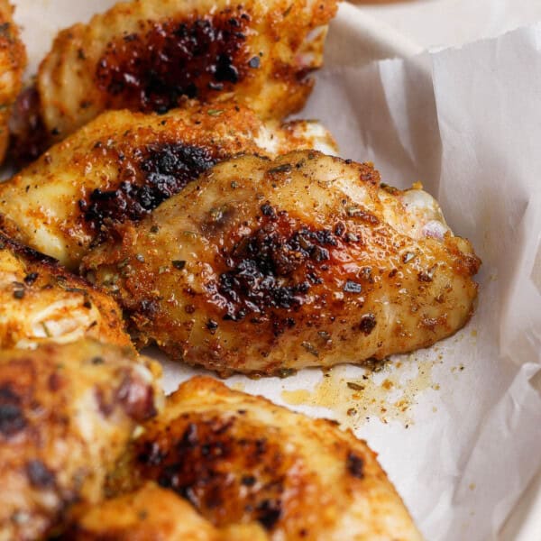 Blackstone chicken wings in a bowl lined with parchment paper.