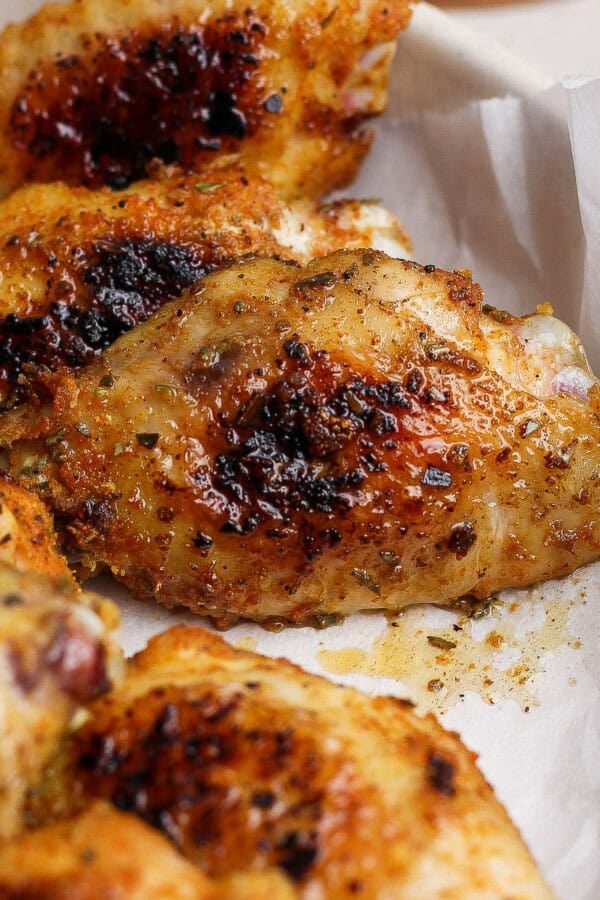 Blackstone chicken wings in a bowl lined with parchment paper.
