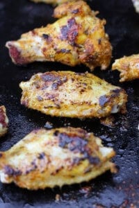 Blackstone chicken wings cooking on the hot griddle.