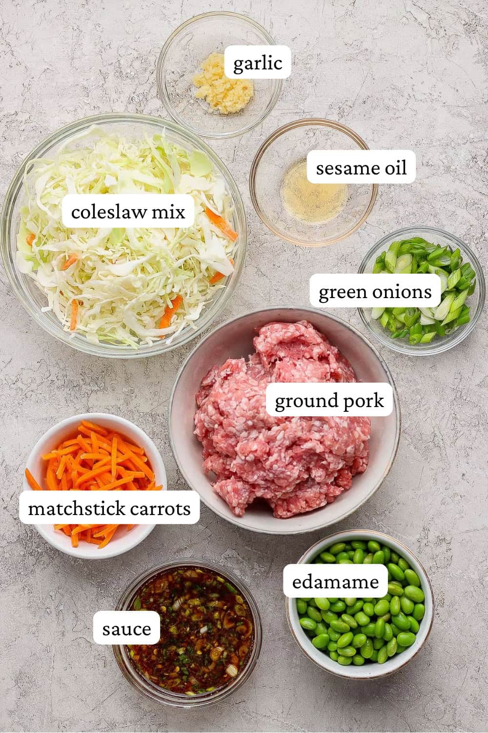 Ingredients for Blackstone egg roll in a bowl in separate bowls with labels.