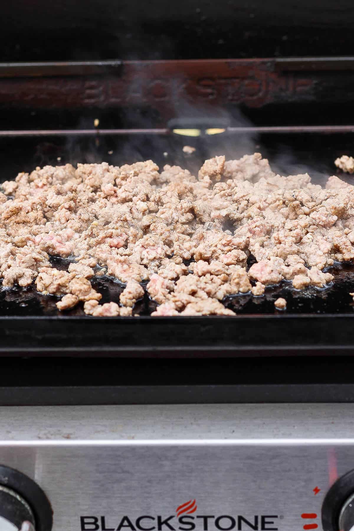 Browned ground pork on the hot cooktop to make Blackstone egg roll in a bowl.