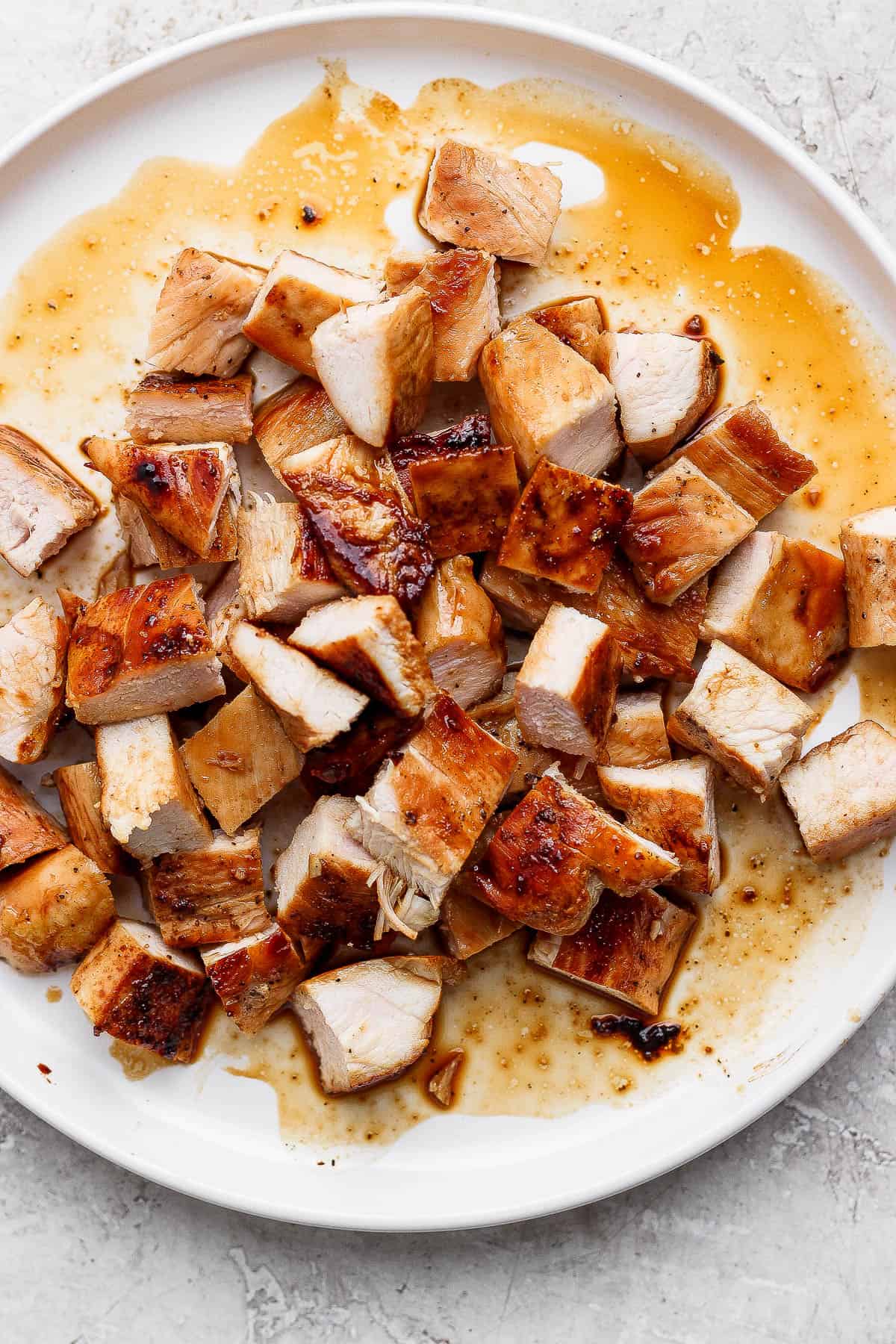 Blackstone chicken breasts cut into cubes on a white plate.