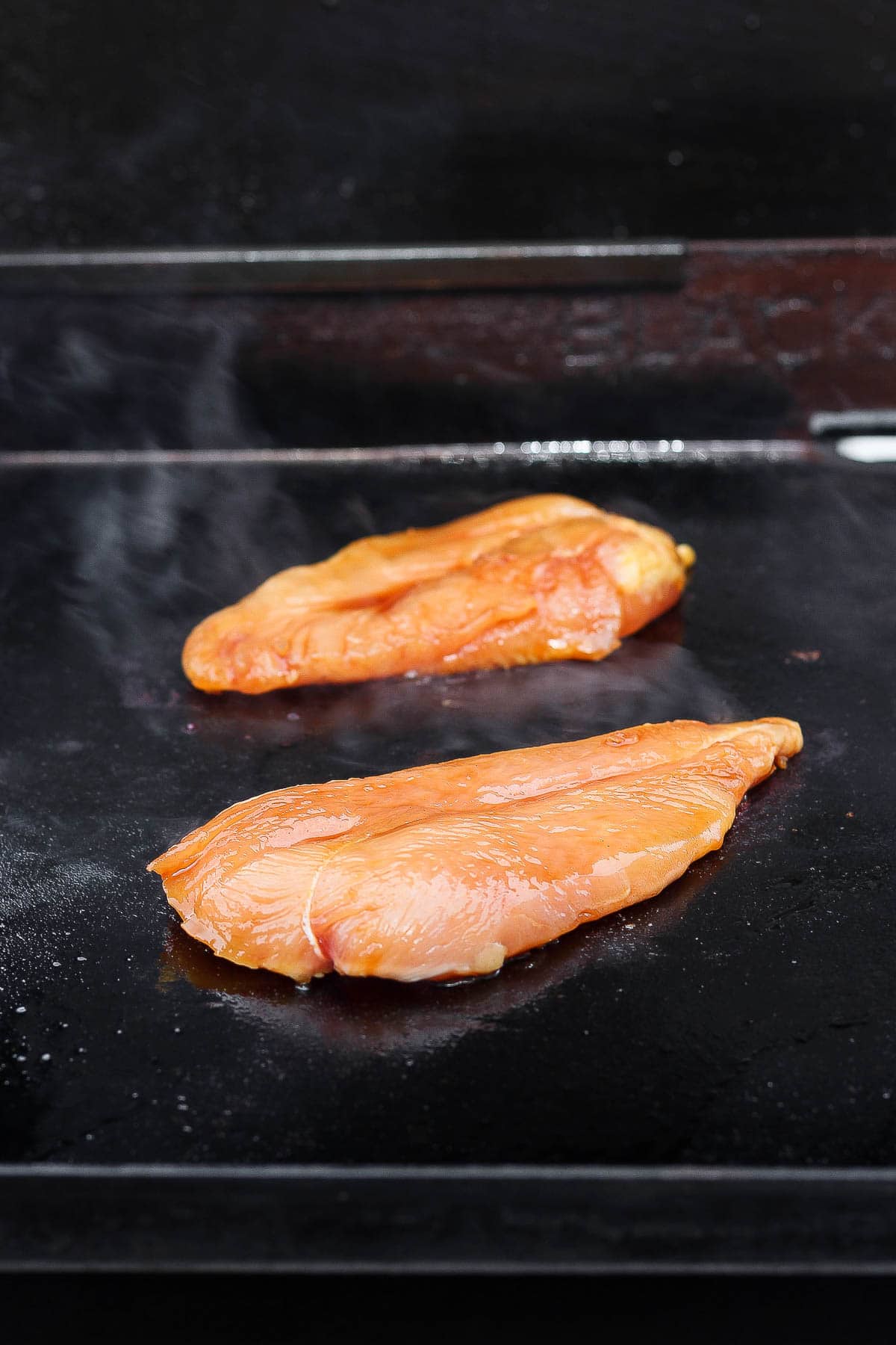 Chicken breasts on the Blackstone at the beginning of cooking.