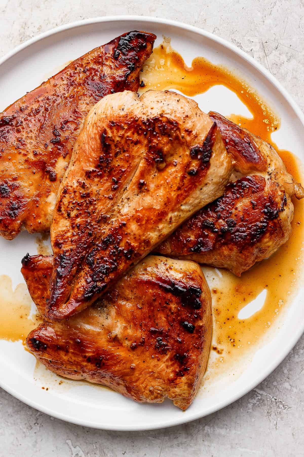 Blackstone chicken breasts resting on a white plate.