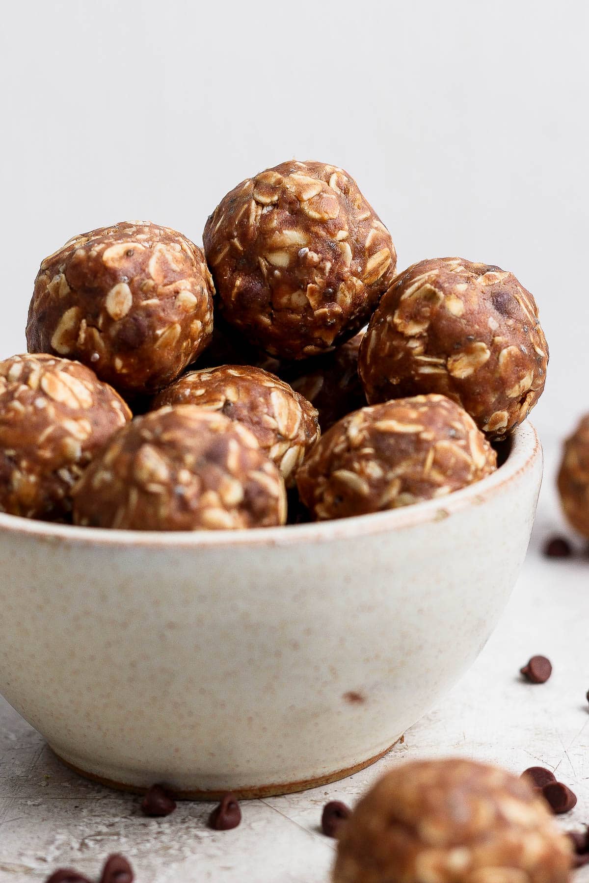 Several chocolate peanut butter energy balls piled in a bowl.