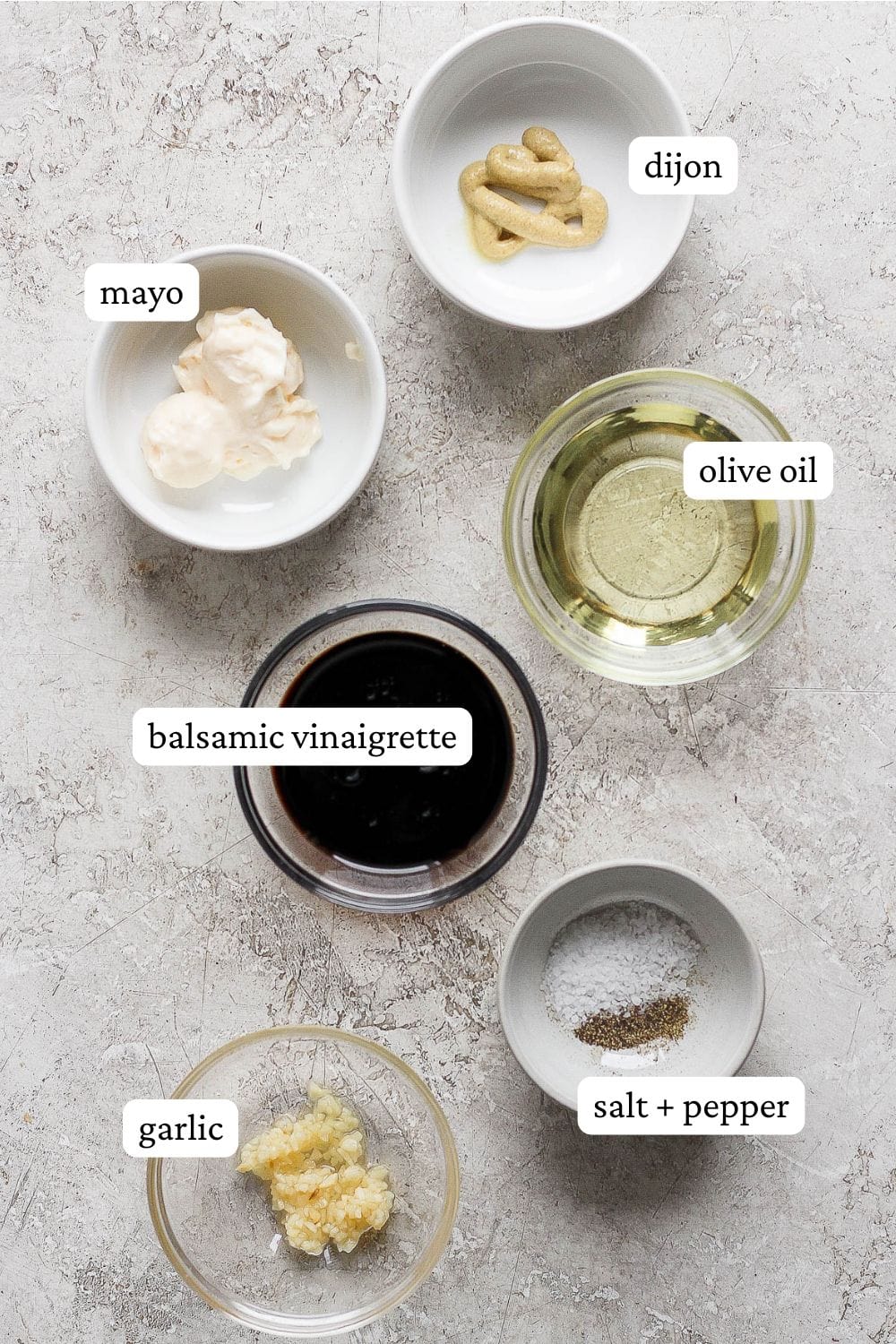 Ingredients for creamy balsamic dressing separated into small bowls and labeled.