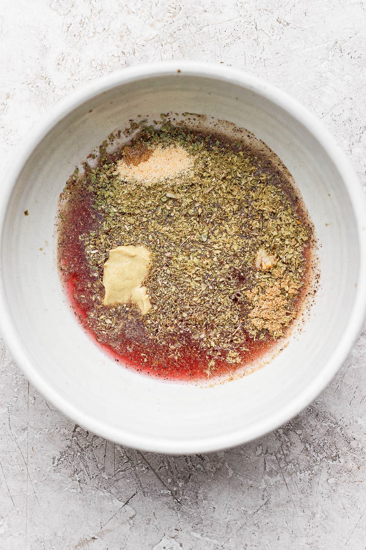 Ingredients for Greek vinaigrette in a bowl before being mixed.