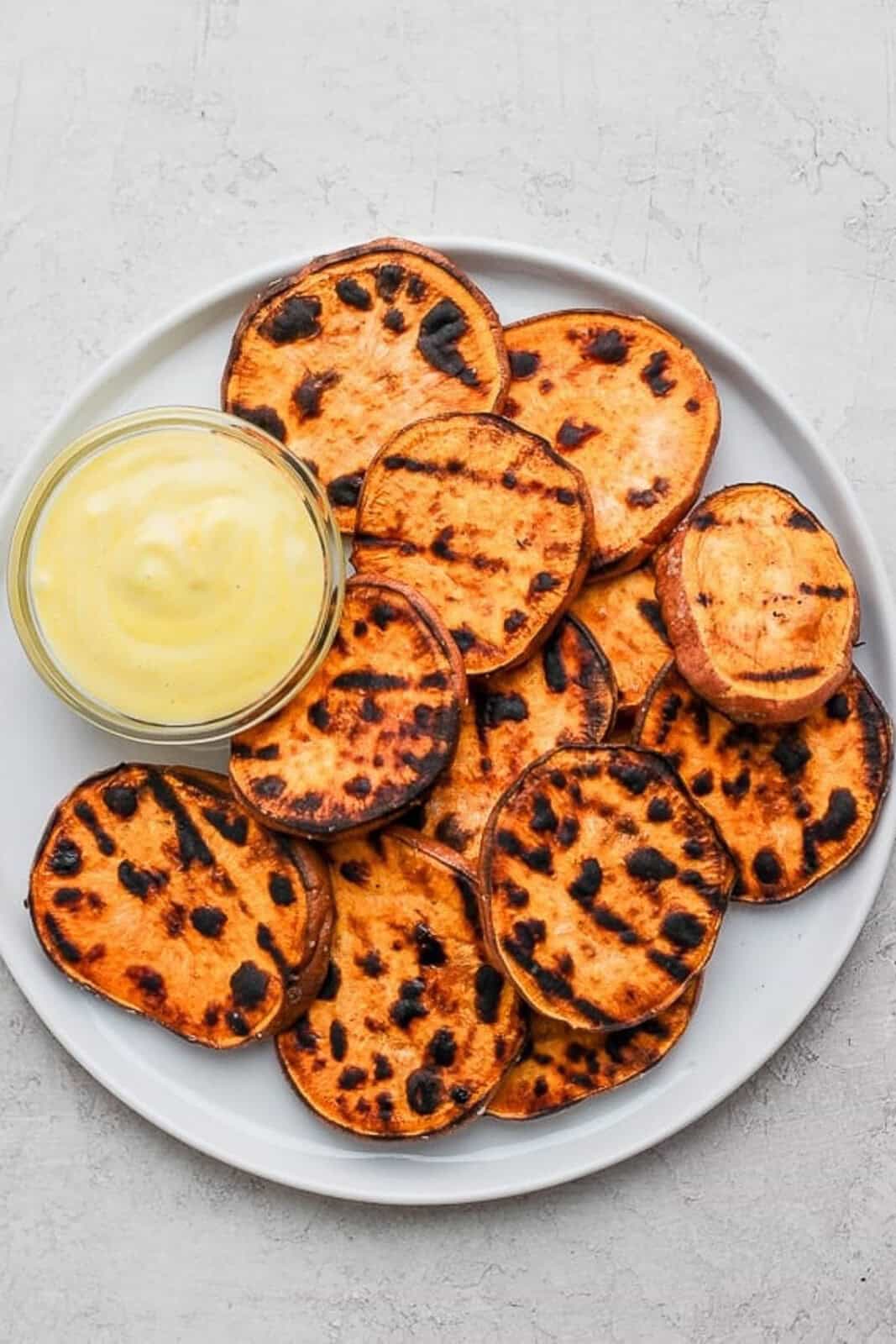 Plate of grilled sweet potatoes with mustard mayo sauce.