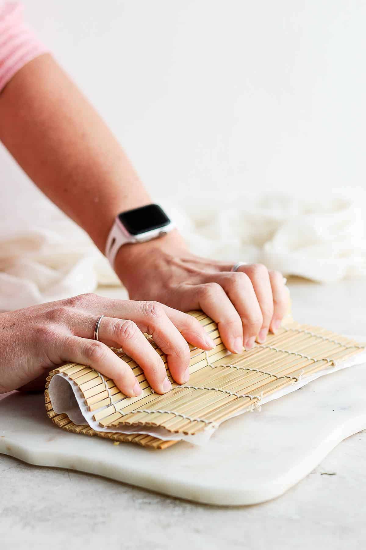 Two hands giving a homemade inside out roll a squeeze during the rolling process.