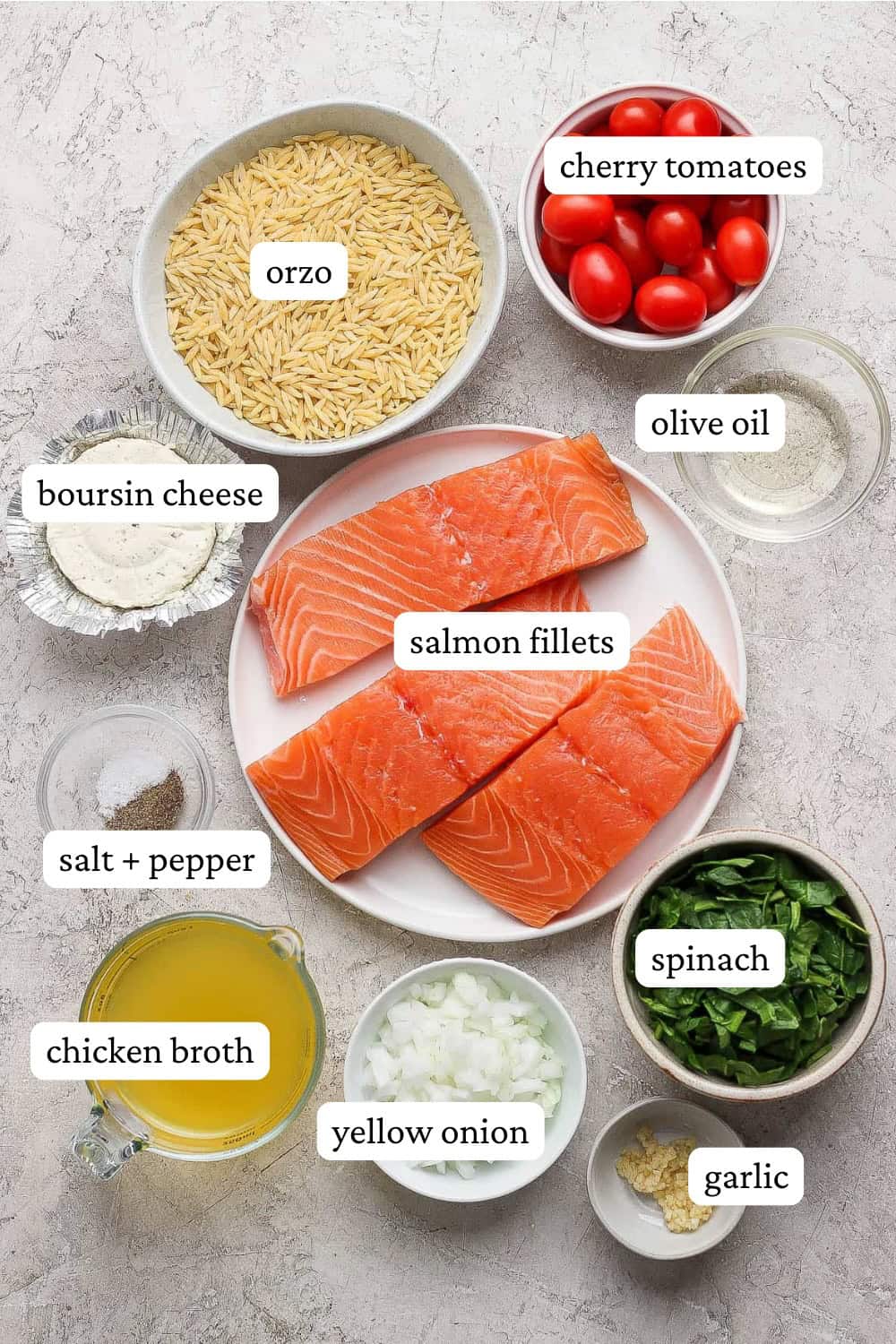 Ingredients for salmon orzo in separate bowls and plates with labels.
