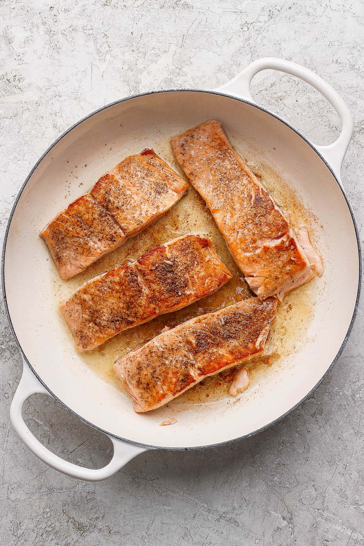 Seared salmon for salmon orzo flipped in the pan and ready to go in the oven.
